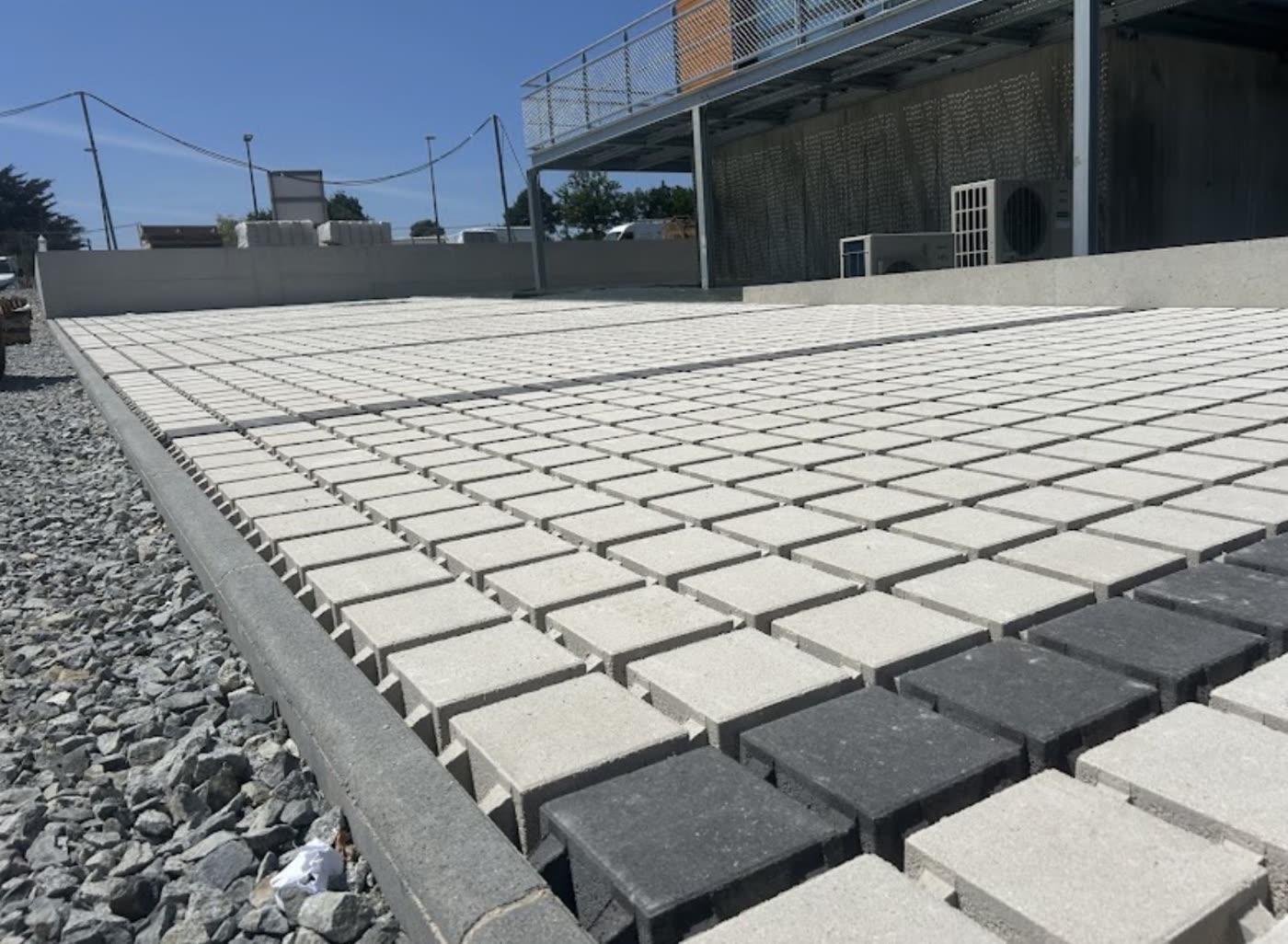Grande surface pavée en dalles claires et sombres réalisée par Erwan TP