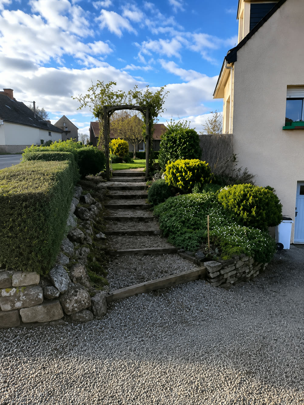 Escalier de jardin en pierre dégradé avant travaux, bordé de haies, à Pleugueneuc